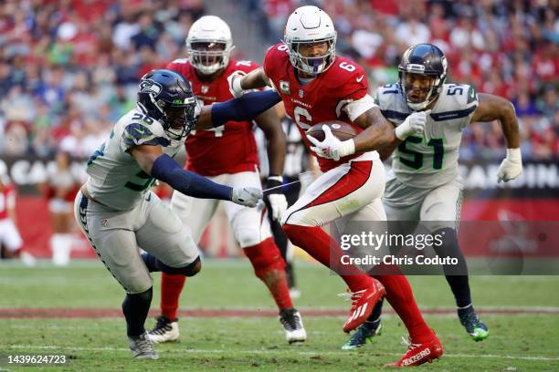 James Conner of the Arizona Cardinals runs by Jordyn Brooks and Bruce Irvin of the Seattle Seahawks during the fourth quarter during the game at...