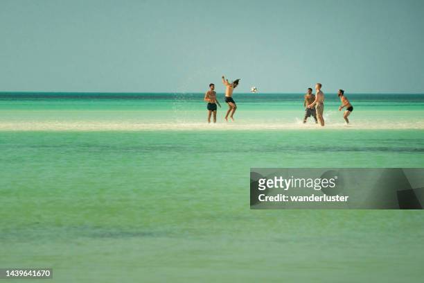 playing soccer on a sandbar in isla holbox, mexico - holbox island stockfoto's en -beelden