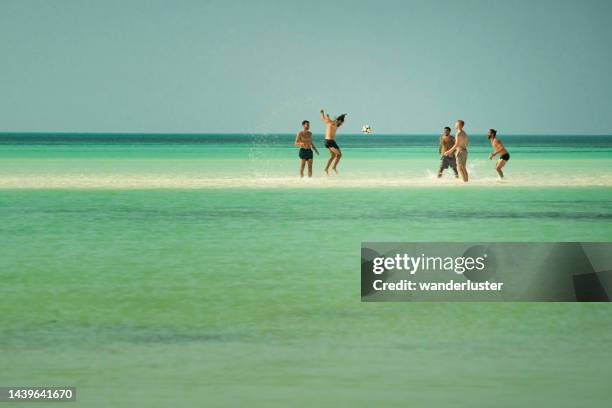 playing soccer on a sandbar in isla holbox, mexico - sandbar stock pictures, royalty-free photos & images