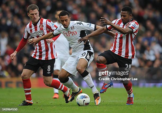 Mousa Dembele of Fulham battles with Craig Gardner and Stephane Sessegnon of Sunderland during the Barclays Premier League match between Fulham and...