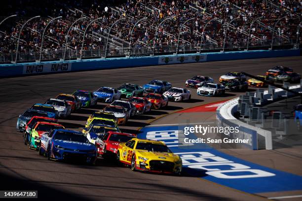 Joey Logano, driver of the Shell Pennzoil Ford, and Kyle Larson, driver of the HendrickCars.com Chevrolet, lead the field during the NASCAR Cup...