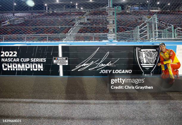 Joey Logano, driver of the Shell Pennzoil Ford, poses next to wall signage with his name and signature on track after winning the 2022 NASCAR Cup...