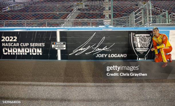 Joey Logano, driver of the Shell Pennzoil Ford, poses next to wall signage with his name and signature on track after winning the 2022 NASCAR Cup...