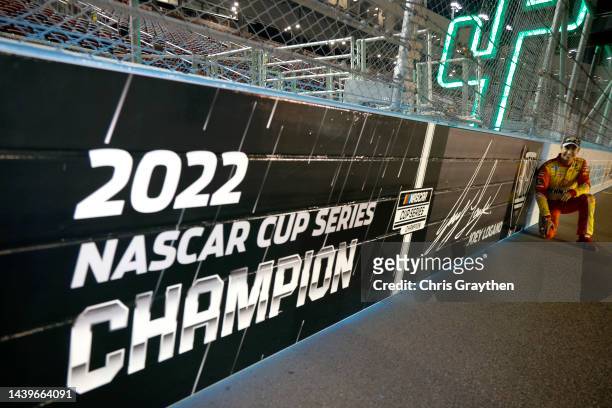 Joey Logano, driver of the Shell Pennzoil Ford, poses next to wall signage with his name and signature on track after winning the 2022 NASCAR Cup...