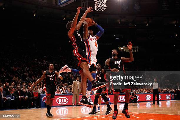 Smith of the New York Knicks drives for a shot attempt in the first half against Shane Battier and LeBron James of the Miami Heat in Game Four of the...
