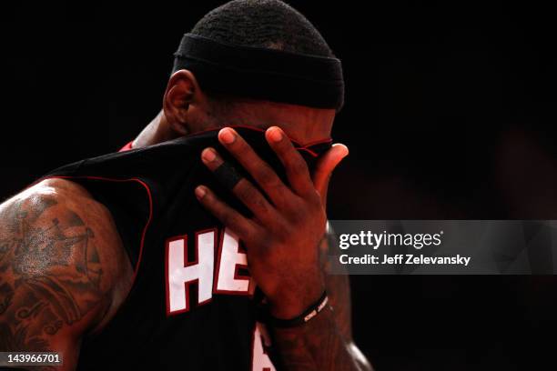 LeBron James of the Miami Heat wipes his face with his jersey in the first half against the New York Knicks in Game Four of the Eastern Conference...