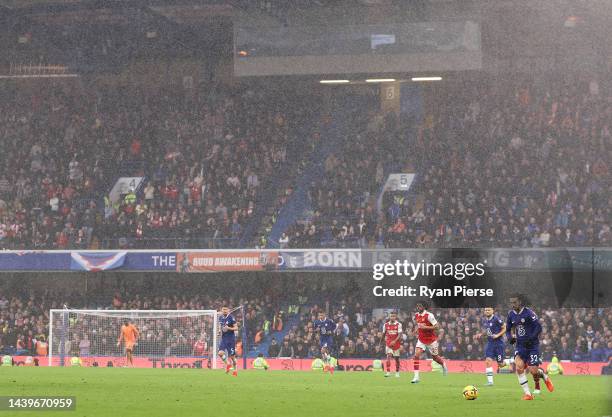 Mark Cucurella of Chelsea passes the ball as rain falls during the Premier League match between Chelsea FC and Arsenal FC at Stamford Bridge on...