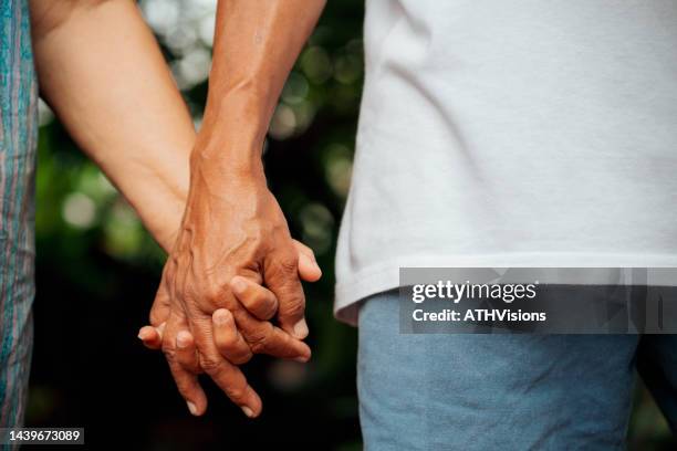 coppia anziana che tiene la mano. amore per sempre - uomo donna per mano foto e immagini stock
