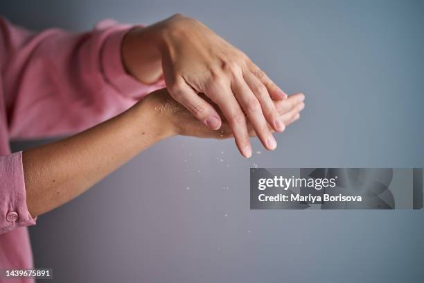 the girl rubs her hands with a dry sugar scrub. - body scrub stock-fotos und bilder