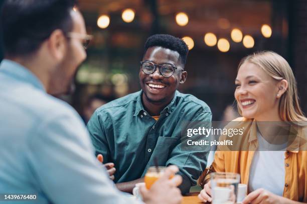 young friends enjoying drinks together - laughing stock pictures, royalty-free photos & images