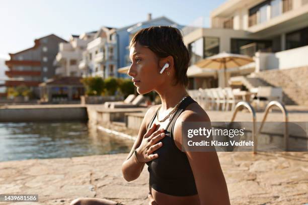 woman practicing breathing exercise - main sur la poitrine photos et images de collection