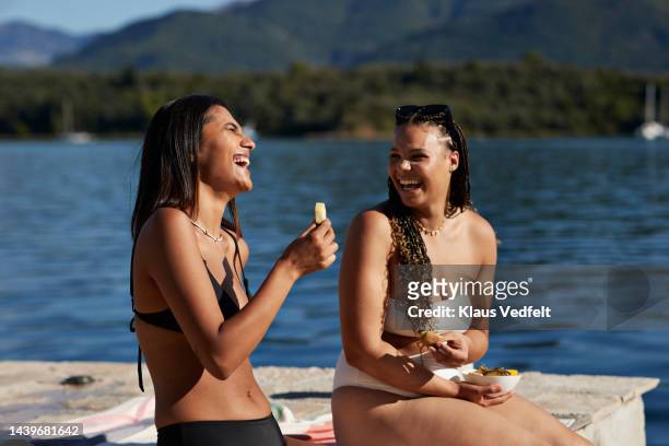 female friends laughing while enjoying summer - beautiful black women in bathing suits stock pictures, royalty-free photos & images