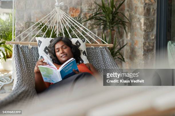 woman reading book in hammock - low depth of field photos et images de collection