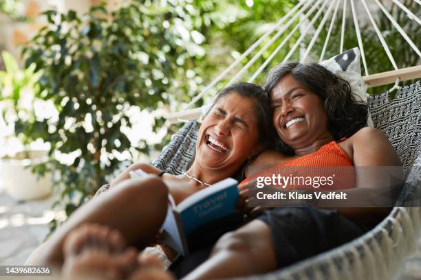 cheerful woman lying with mother in hammock - lifestyle imagens e fotografias de stock