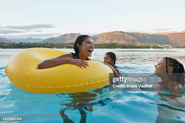 happy woman enjoying with friends in swimming pool - glory tube stock-fotos und bilder