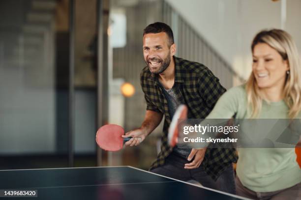 happy couple having fun while playing table tennis. - table tennis stock pictures, royalty-free photos & images