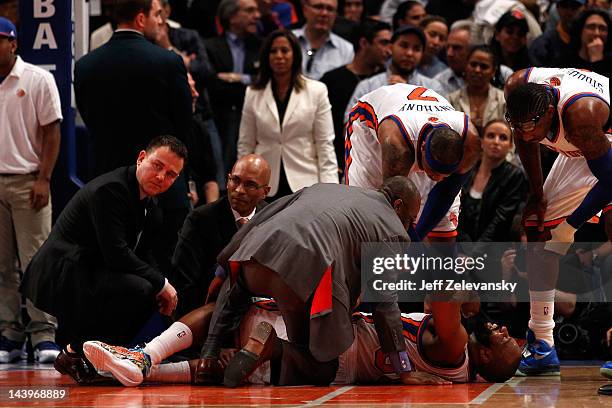 Baron Davis of the New York Knicks is tended to by the team medical staff as players Carmelo Anthony and Amare Stoudemire after Davis injured his...