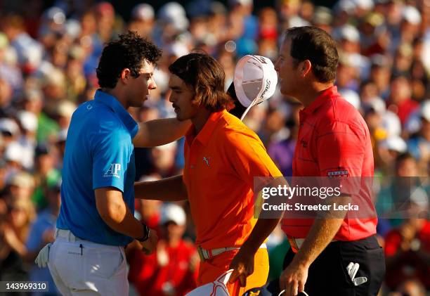 Rickie Fowler of the United States is congratulated by Rory McIlroy of Northern Ireland and D.A. Points of the United States after making a putt for...