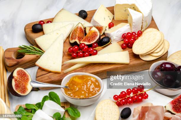 cheese board set of italian and french cheeses with figs and red currants. parmesan, pecorino, goat cheese on a marble board. a cheese plate in the restaurant for white wine and aperitif - table aperitif stock pictures, royalty-free photos & images