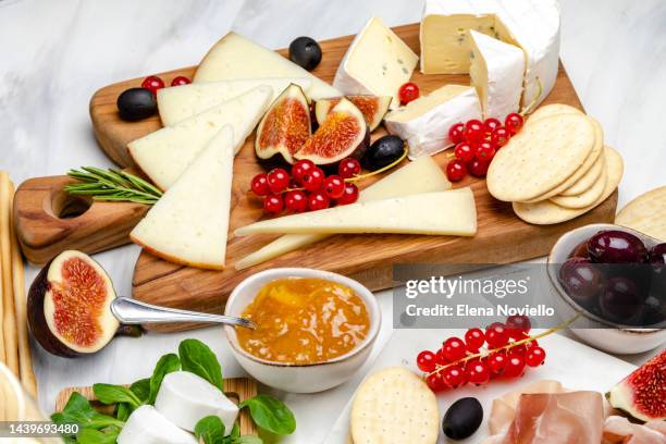cheese board set of italian and french cheeses with figs and red currants. parmesan, pecorino, goat cheese on a marble board. a cheese plate in the restaurant for white wine and aperitif - ostbricka bildbanksfoton och bilder