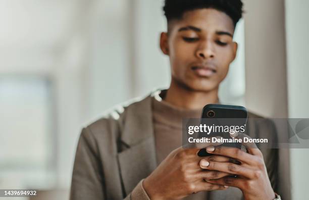 black man, phone and typing on social media, scroll and browse online with serious face. young male, with smartphone and have conversation for research, chat or  communication fun, message and mockup - serious teenager boy stock pictures, royalty-free photos & images