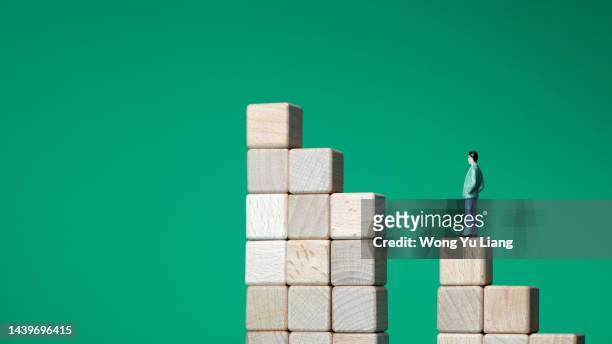 toy man climbing corporate ladder gap , business working challenge - achievement gap stock pictures, royalty-free photos & images