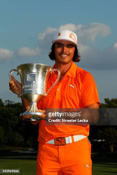 Rickie Fowler of the United States celebrates with the championship trophy after defeating Rory McIlroy of Northern Ireland and D.A. Points of the...