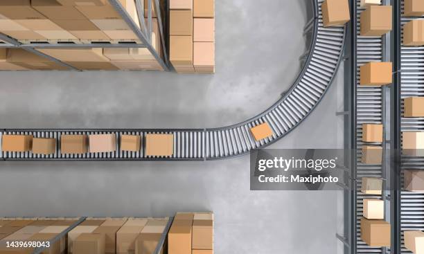 top view of conveyor belts transporting boxes in a large warehouse - lopende band stockfoto's en -beelden
