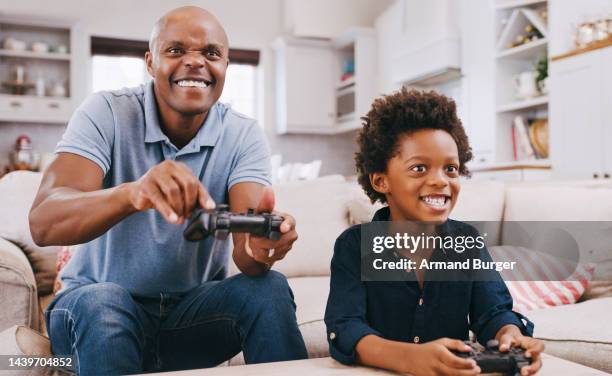 père jouant à un jeu vidéo avec l’enfant sur le canapé, s’amusant et profitant du week-end ensemble. famille noire, amour et père heureux avec son fils jouant à des jeux informatiques pour le divertissement, contrôleur dans les mains - command sisters photos et images de collection