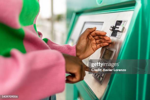 unrecognizable young adult african woman hand entering personal identification number on atm dial panel - millennial person withdrawing money at automatic atm machine typing secret security code number - atm stock pictures, royalty-free photos & images