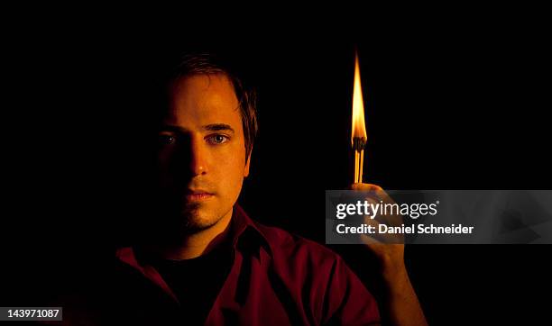 man holding match with bright flame - matchstick man stock pictures, royalty-free photos & images