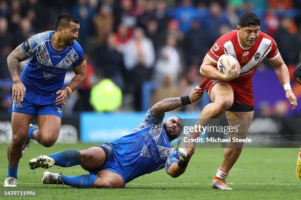 Jason Taumalolo of Tonga is held up by Junior Paulo of Samoa during Rugby League World Cup Quarter Final match between Tonga and Samoa at The...