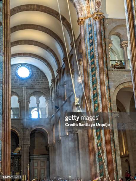 botafumeiro swinging in santiago de compostela cathedral during a mass for pilgrims - santiago de compostela cathedral stock pictures, royalty-free photos & images