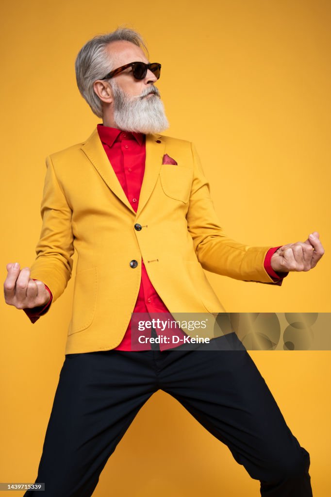 Happy well dressed gentleman having photoshooting in studio