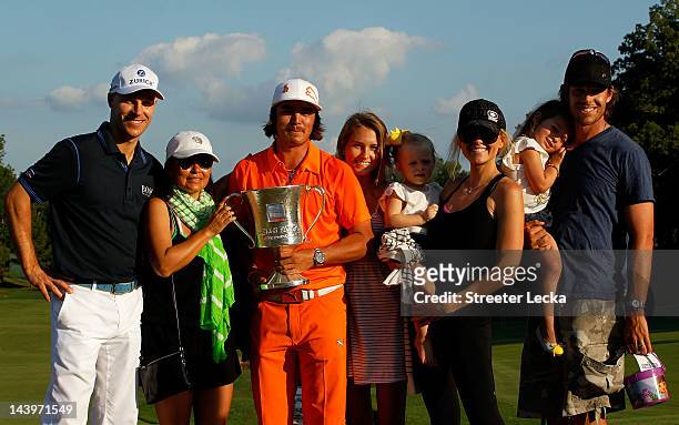 Rickie Fowler of the United States celebrates with the championship trophy alongside his mother Lynne Fowler , girlfriend Alexandra Brown , golfer...