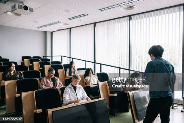 group of students attending university seminar - social distancing classroom stockfoto's en -beelden