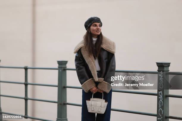 Anna Winter is seen wearing grey/beige checked Miu Miu beret hat, white turtleneck from Weekday, brown doubleface jacket from Zara, dark blue Closed...