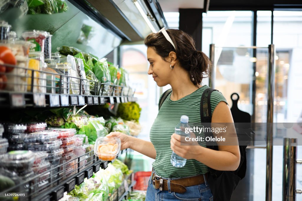 Portrait of a young woman buying fresh vegetables at the grocery store