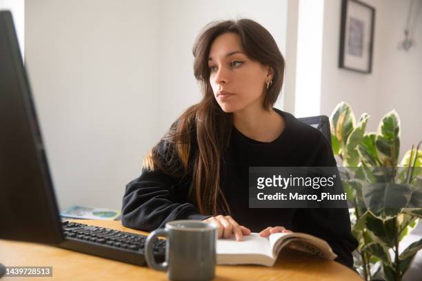 donna che studia e usa il computer - manuale foto e immagini stock