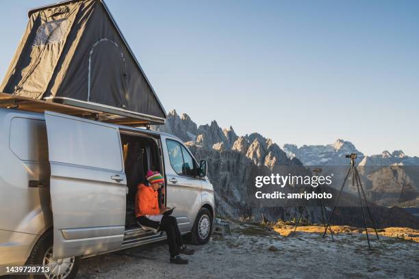 frau während abenteuercampingreise in dolomiten - lieferwagen stock-fotos und bilder