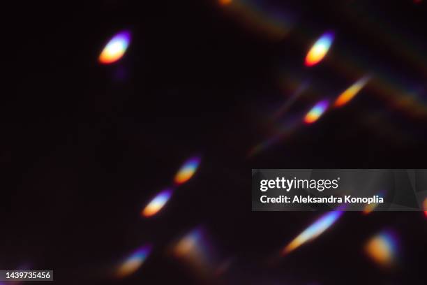 colourful rainbow disco ball light leaks texture on black background - sfocato foto e immagini stock