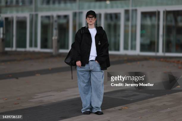 Maria Barteczko seen wearing a black oversized rain coat by Balenciaga, light blue washed oversized baggy jeans by Source Unknown, black leather...