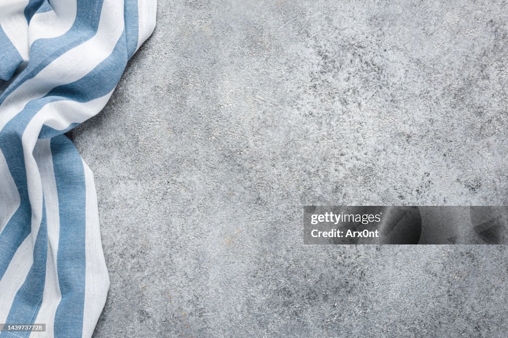 Blue striped kitchen towel on grey concrete background