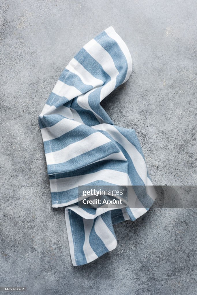 Blue triped kitchen towel on grey background