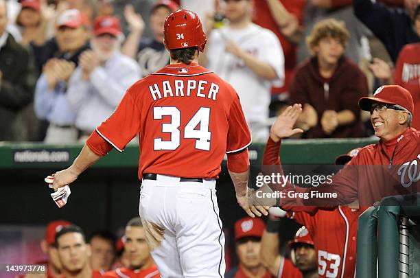 Bryce Harper of the Washington Nationals celebrates with manager Davey Johnson after stealing home plate in the first inning against the Philadelphia...