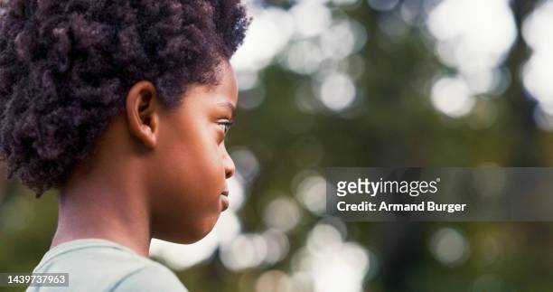 thinking, anxiety and depression with boy child in nature or park. african kid looking serious in a garden or playground, feeling sad and alone - alleen één jongen stockfoto's en -beelden