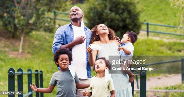covid, freedom and family taking off mask in park to breath fresh air, parents enjoy outdoors with children. happiness, joy and relief in black family to remove face mask for end of covid 19 pandemic - relief facial expression stock pictures, royalty-free photos & images