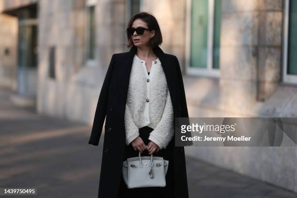 Patricia Wirschke is seen wearing brown Céline sunglasses, white/creme fluffy cardigan from Massimo Dutti, black shorts, black tights, white/light...