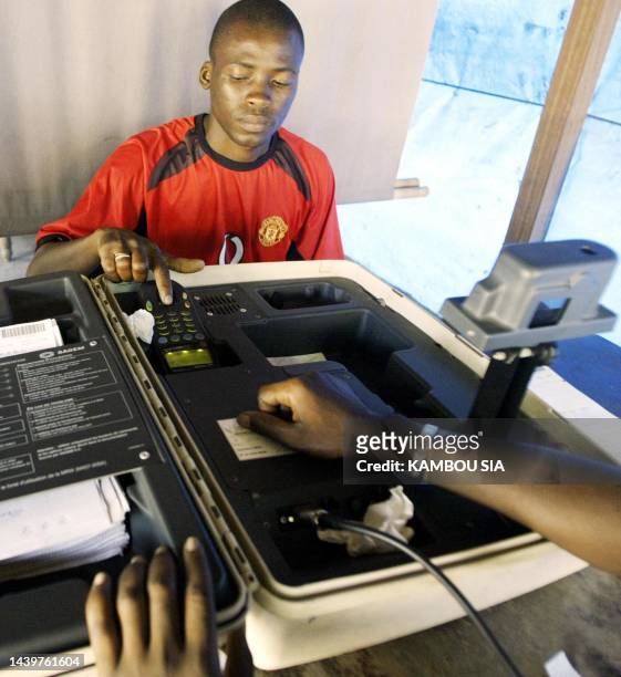 Local inhabitant of the Koumassi area is being taken his fingerprints 09 February 2005, in Abidjan. The Ivory Coast resume issuing its 17 million...