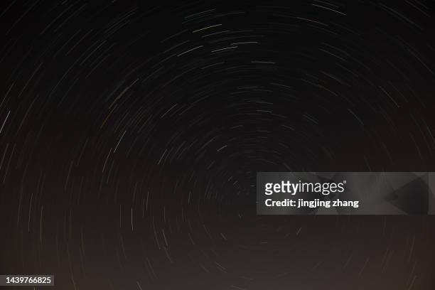 long exposure, multiple photos of the star orbit orbiting the north star - north star background stock pictures, royalty-free photos & images